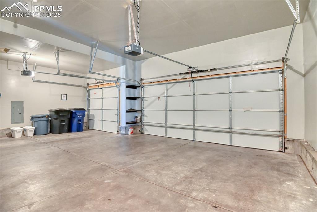 Image 38 of 45: Garage with electric panel and a garage door opener