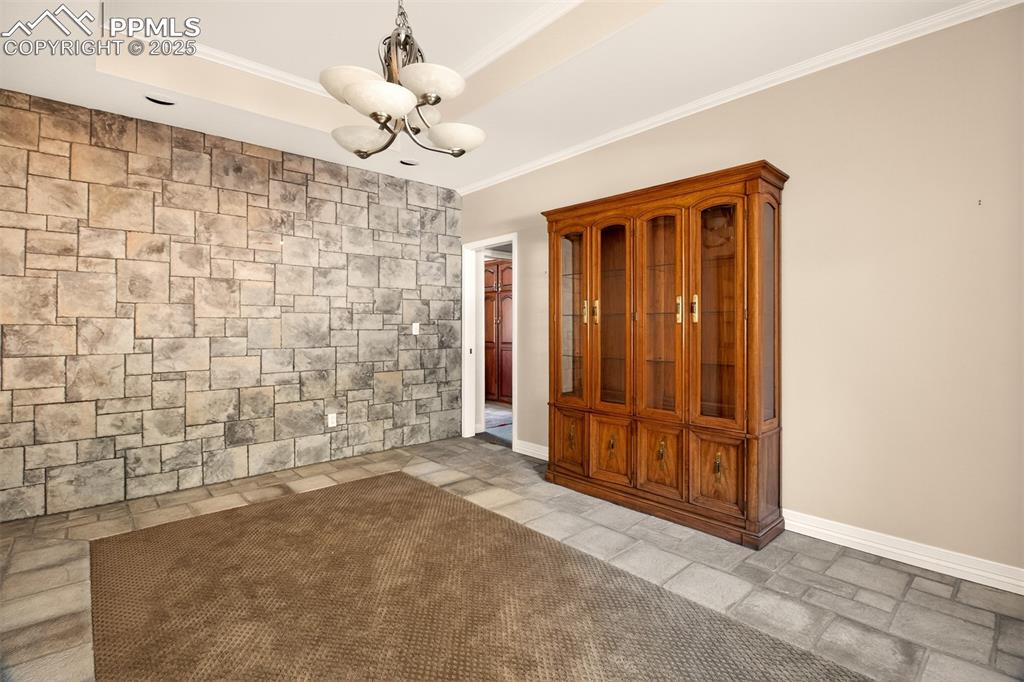Image 18 of 50: Formal dining room has carpet inlay in manmade stone floor