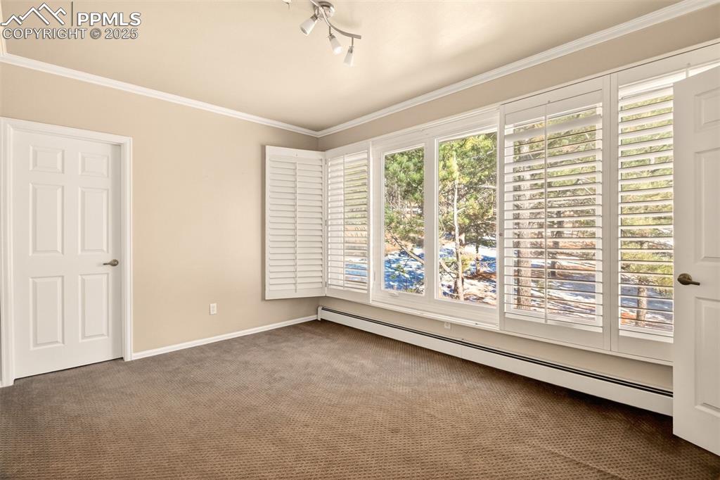 Image 34 of 50: 4th bedroom on upper level has plantation shutters
