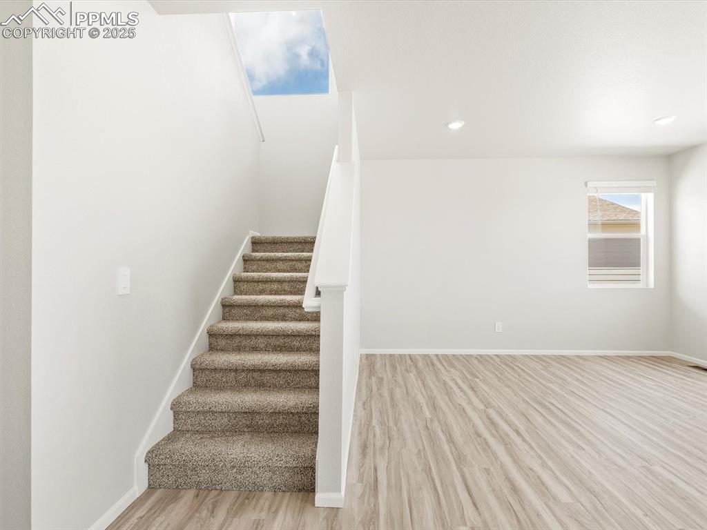 Image 15 of 44: Stairway featuring wood finished floors and recessed lighting
