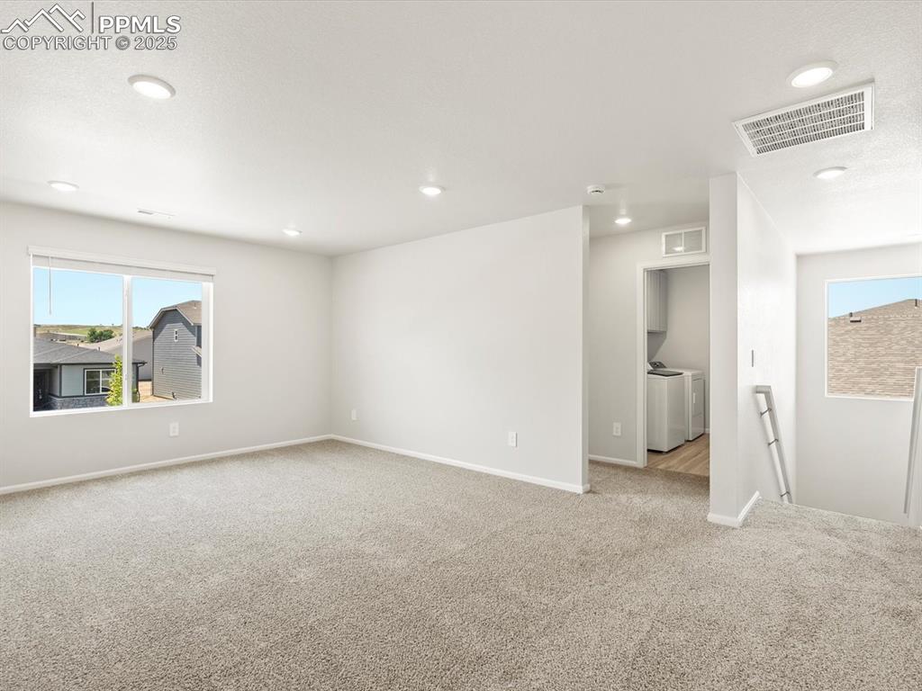 Image 20 of 44: Unfurnished room with healthy amount of natural light, light colored carpet