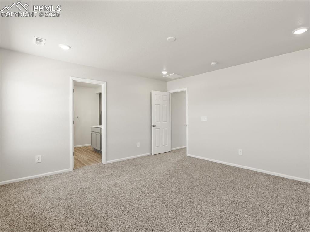 Image 25 of 44: Unfurnished bedroom featuring ensuite bathroom, light carpet, and recessed 