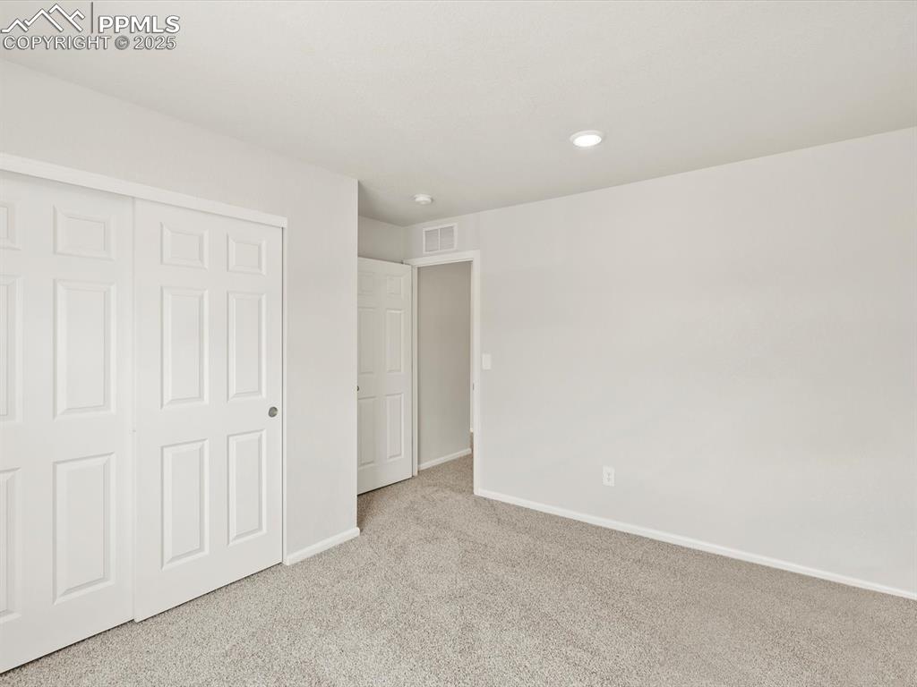 Image 27 of 44: Unfurnished bedroom featuring carpet floors, a closet, and recessed lightin