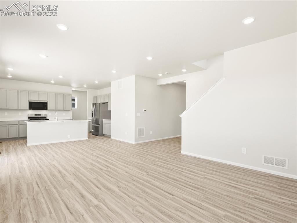 Image 3 of 44: Unfurnished living room featuring light wood finished floors and recessed l