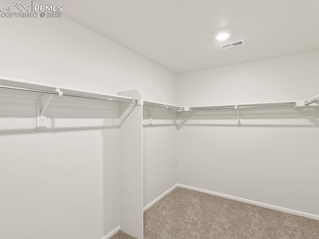 Image 36 of 44: Walk in closet with light colored carpet