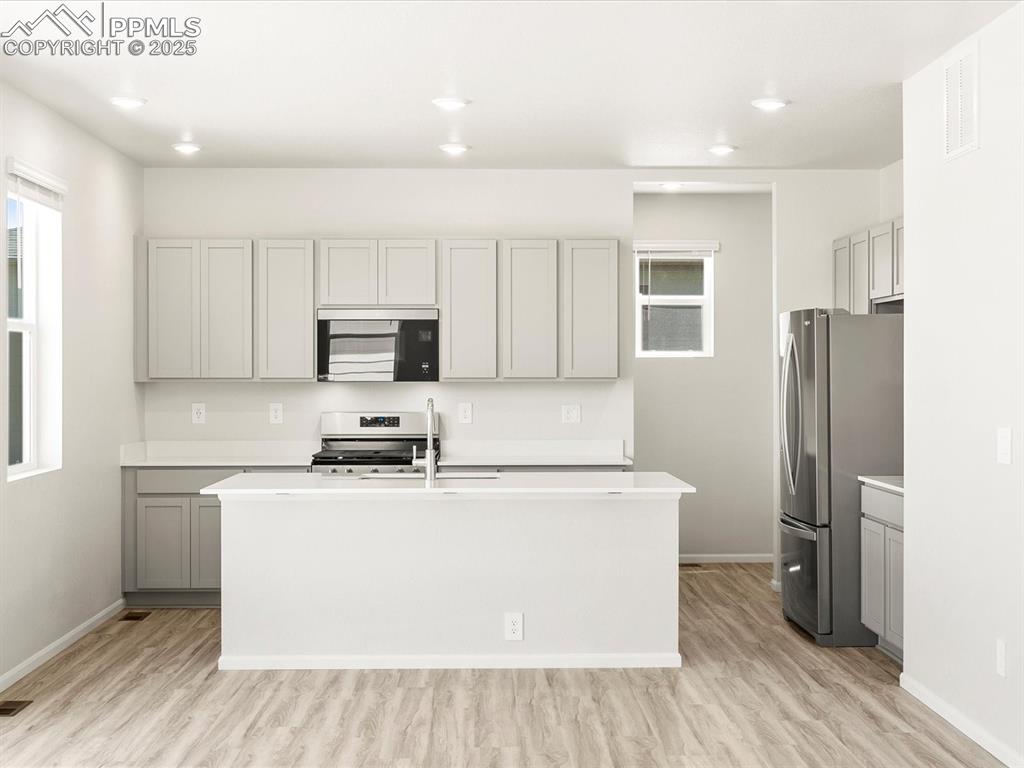 Image 6 of 44: Kitchen with gray cabinets, appliances with stainless steel finishes, an is