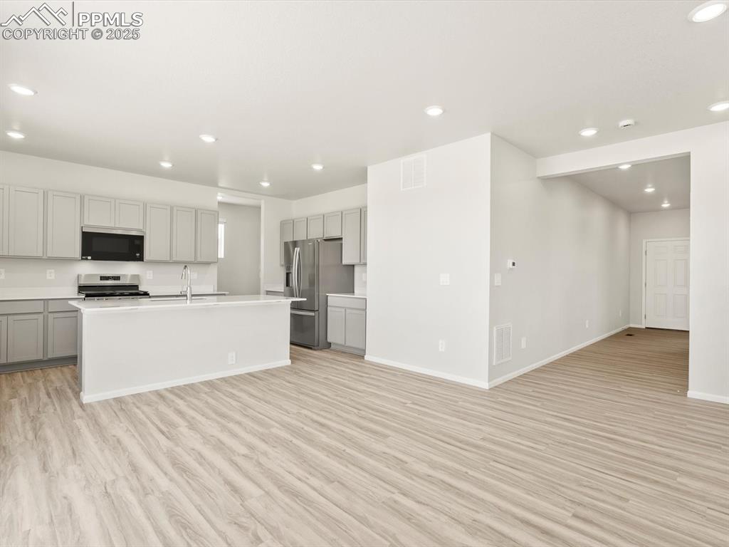 Image 8 of 44: Kitchen featuring recessed lighting, gray cabinets, light wood-type floorin
