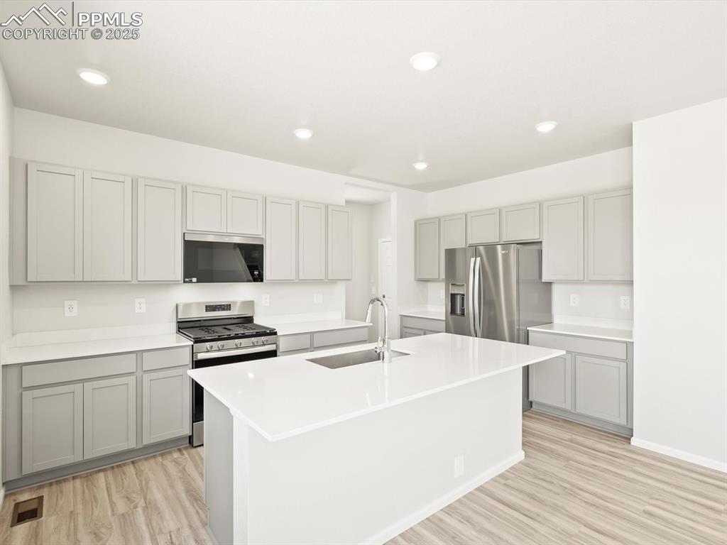 Image 9 of 44: Kitchen featuring stainless steel appliances, recessed lighting, light wood