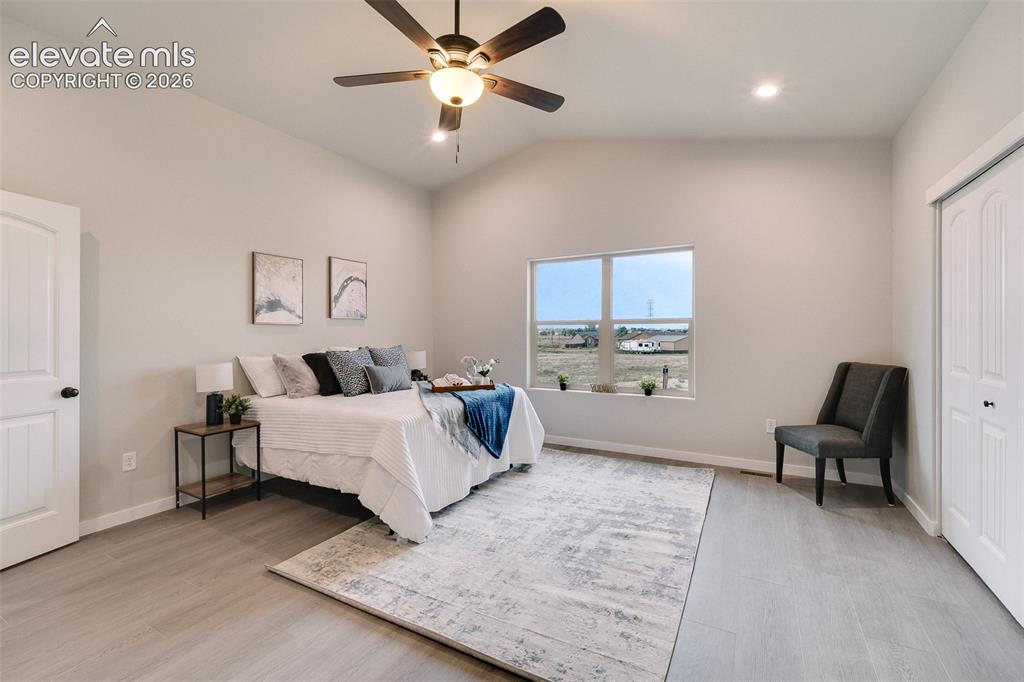 Image 15 of 28: Vaulted ceiling with a ceiling fan, recessed lighting, wood-finish flooring
