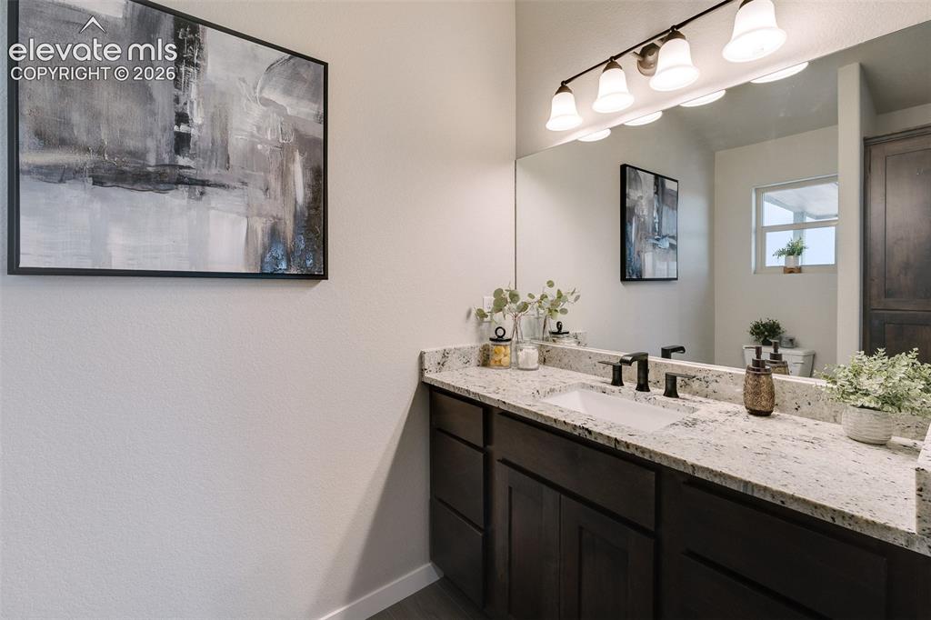 Image 17 of 28: Spacious vanity with a white rectangular undermount sink, black faucet, and