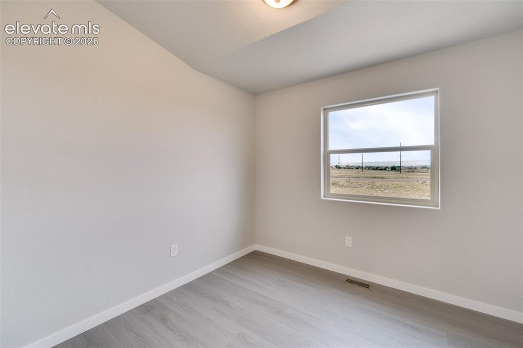 Image 21 of 28: Neutral wall finishes, wood-finish flooring, and white trim