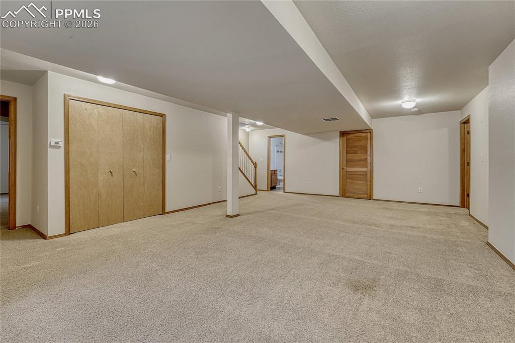 Image 29 of 48: Head down the open staircase to discover the sprawling finished basement, w
