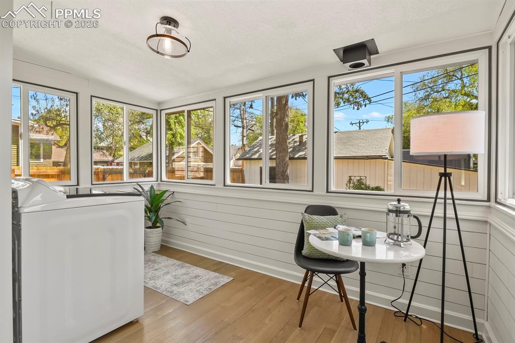 Image 20 of 40: Sunroom/laundry room with rows of windows and room for a breakfast nook