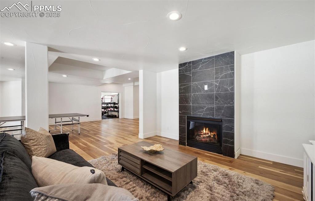 Image 13 of 31: Living room featuring light wood-style floors, a fireplace, and recessed li