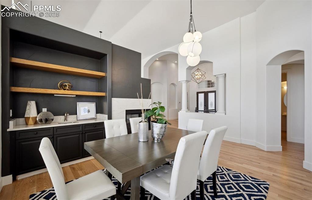 Image 5 of 31: Dining room featuring light wood-style flooring, arched walkways, and built