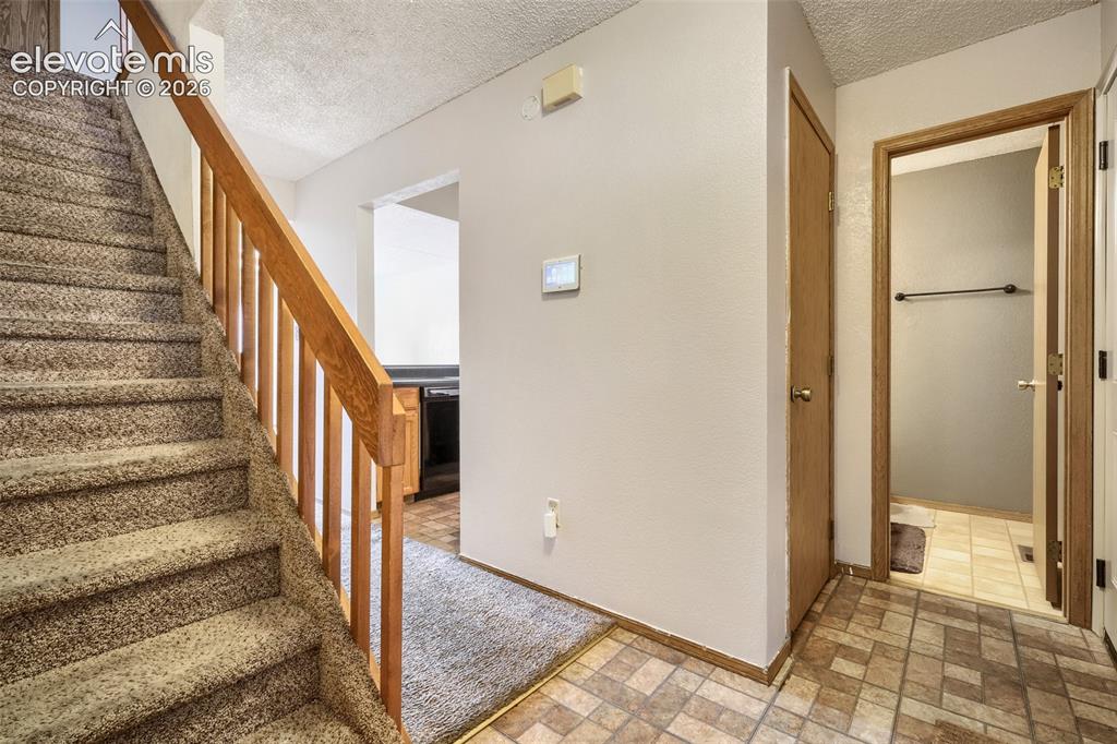 Image 18 of 35: Carpeted staircase with wooden handrail and balusters