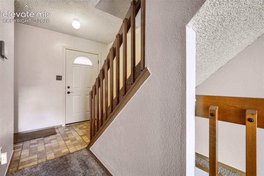Image 19 of 35: Entryway featuring a white door with an arched transom, tile flooring, and