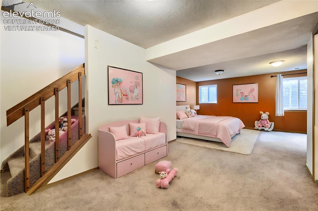 Image 21 of 35: Virtually Staged - Carpeted lower level room featuring a built-in staircase
