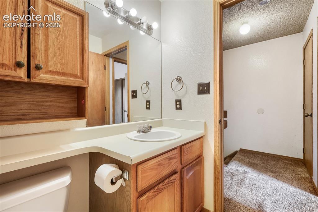 Image 24 of 35: Bathroom featuring a vanity with a recessed sink, a large mirror, and a mul