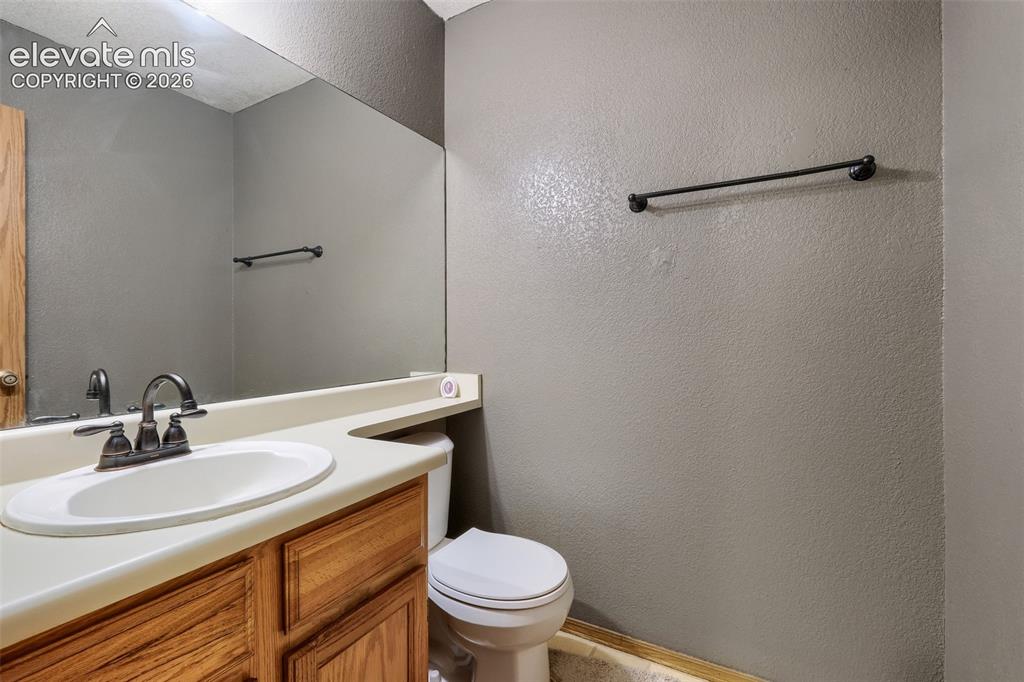 Image 27 of 35: Bathroom with a built-in wood-finish vanity and integrated sink