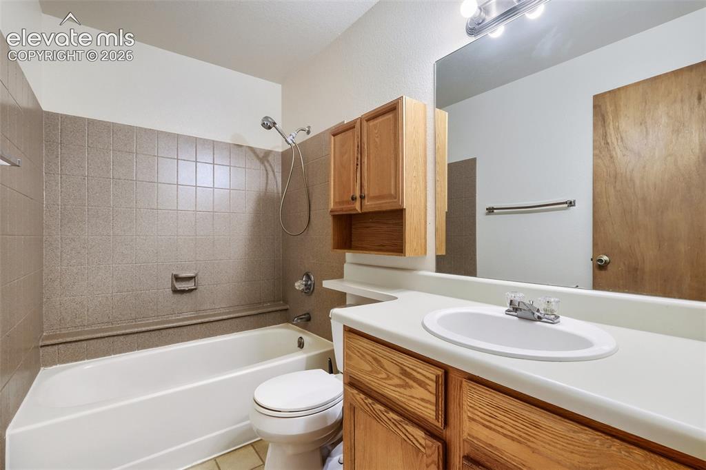 Image 28 of 35: Bathroom featuring a full vanity with an integrated sink, a large wall-moun