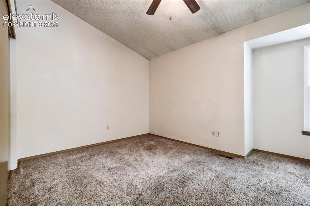 Image 29 of 35: Room featuring vaulted ceilings and neutral wall paint