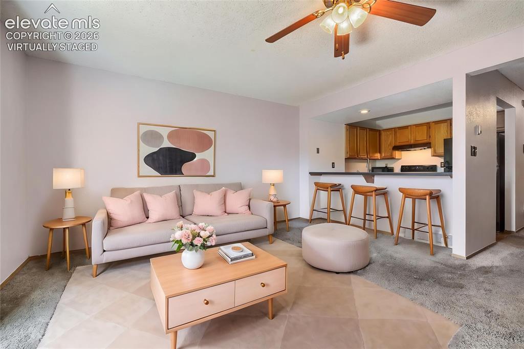 Image 5 of 35: Virtually Staged - Living space with light-toned walls and carpeted floorin