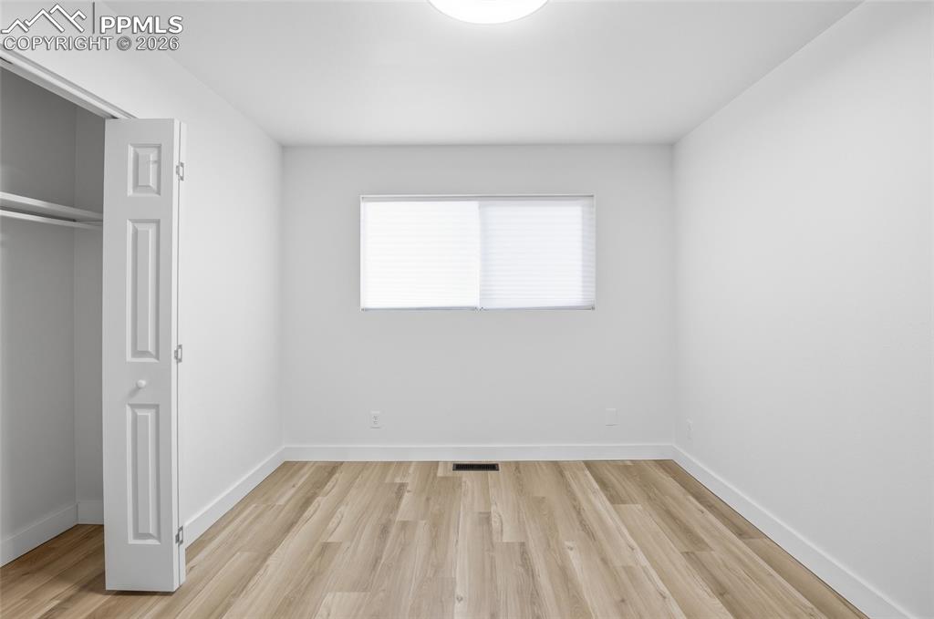 Image 10 of 44: Room featuring light-colored flooring, white walls, and a window with blind