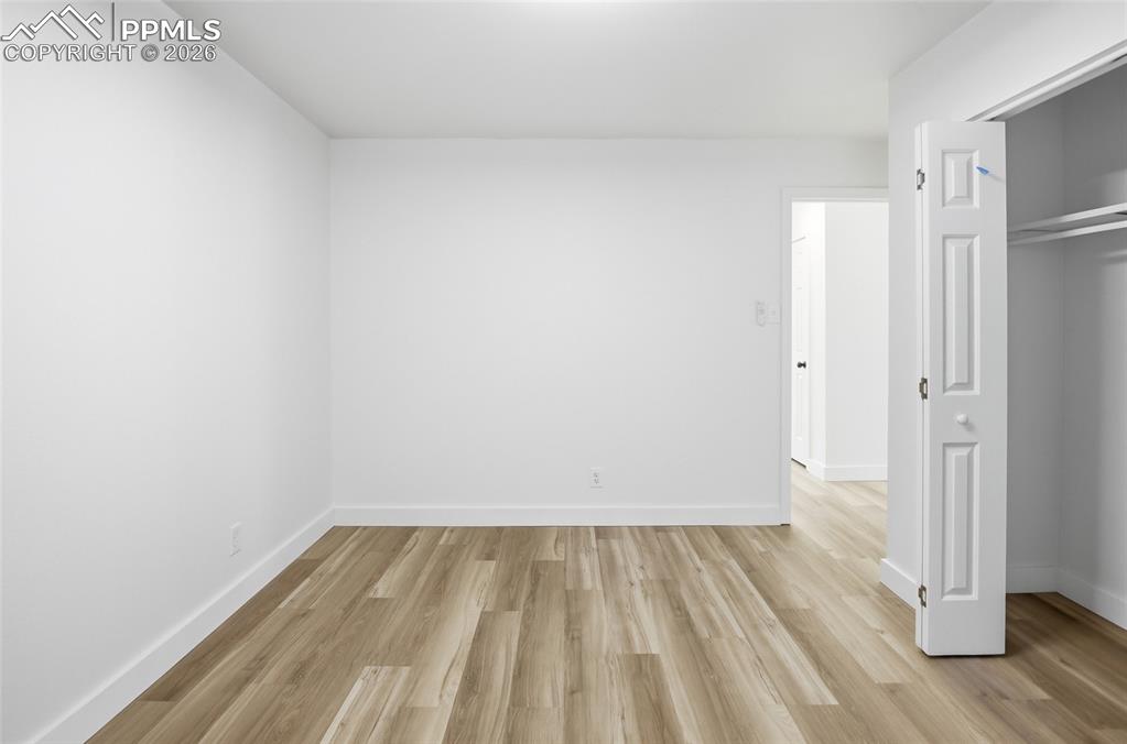 Image 11 of 44: Spacious room featuring light wood-look flooring and white walls