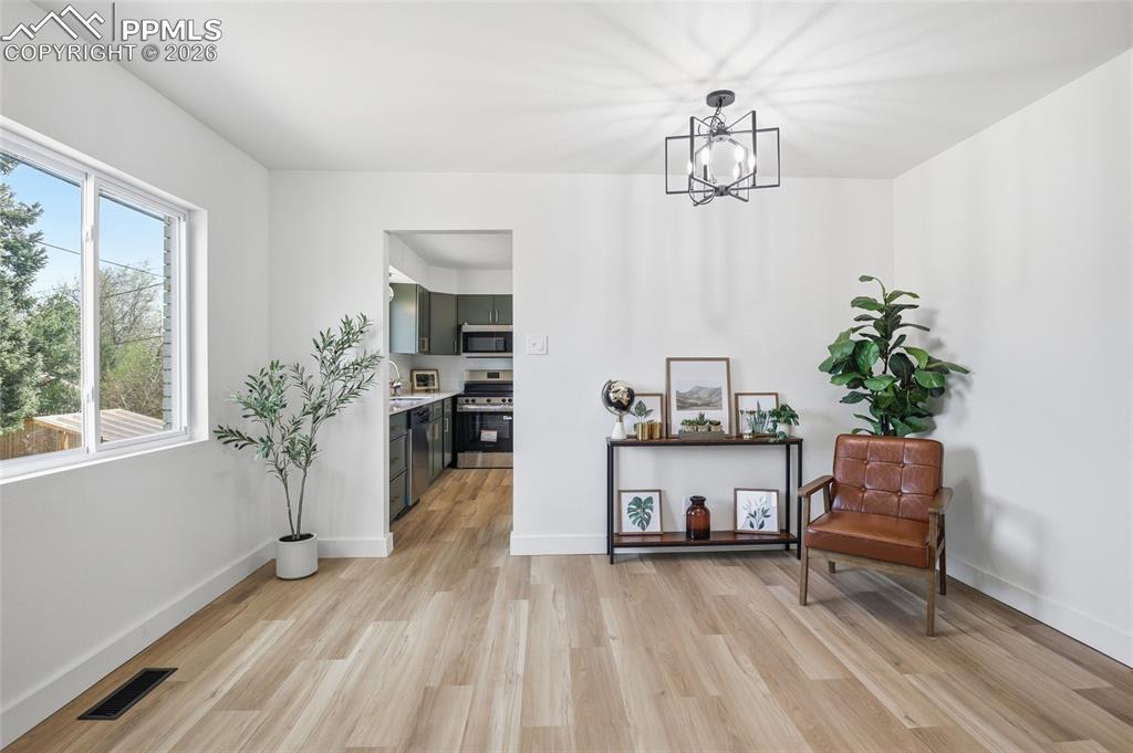 Image 18 of 44: This bright living space features light-toned flooring and white walls, cre