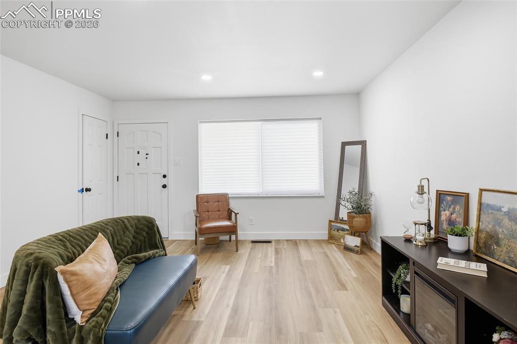 Image 21 of 44: The living area features light-colored flooring, white walls, and a front e