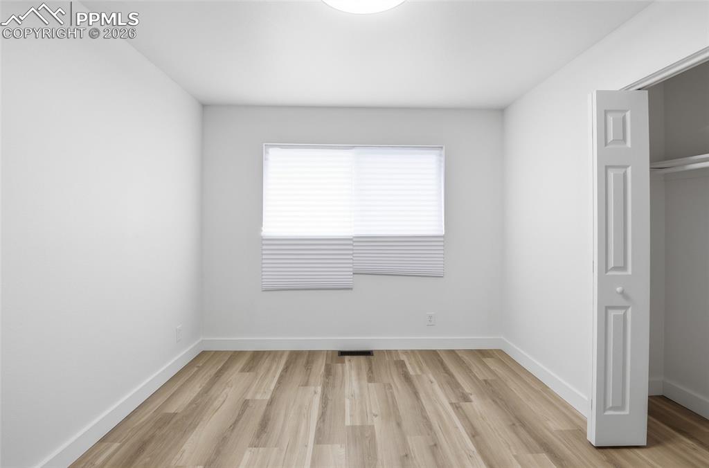 Image 26 of 44: Bright room featuring light-toned flooring, a window with blinds, and white
