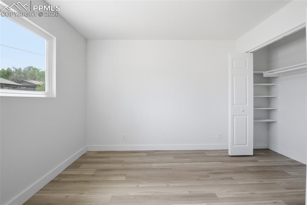 Image 29 of 44: This room features light-toned wood-style flooring, a window providing natu