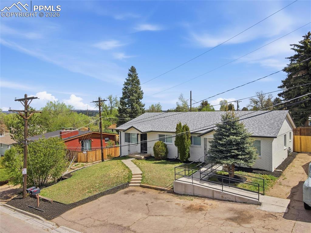 Image 37 of 44: The property features a ranch-style exterior with light-colored brick, a gr