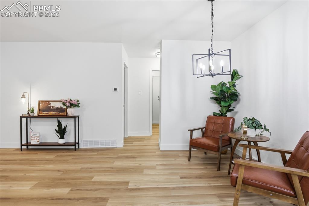Image 6 of 44: The property features light wood flooring, white walls, and a modern light 