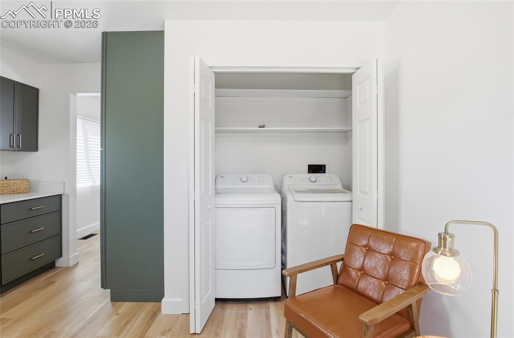 Image 9 of 44: Dedicated laundry area featuring a washer and dryer, accompanied by shelvin