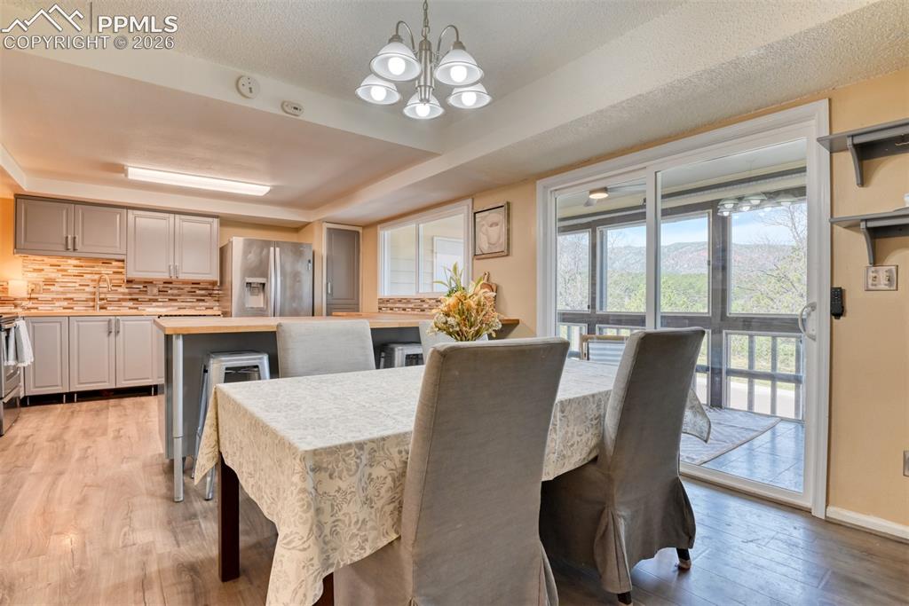 Image 14 of 38: Dining space walks out to the dedk with new ceiling fan for additional eati