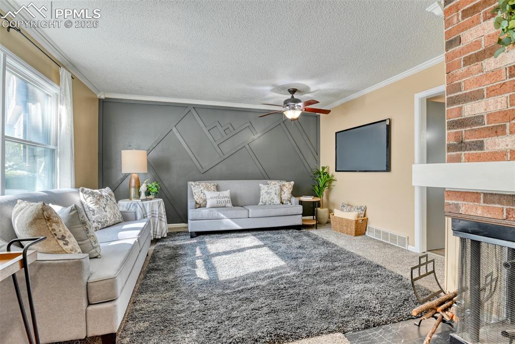 Image 5 of 38: Living room is spacious and has wood burning fireplace. Photo taken from th