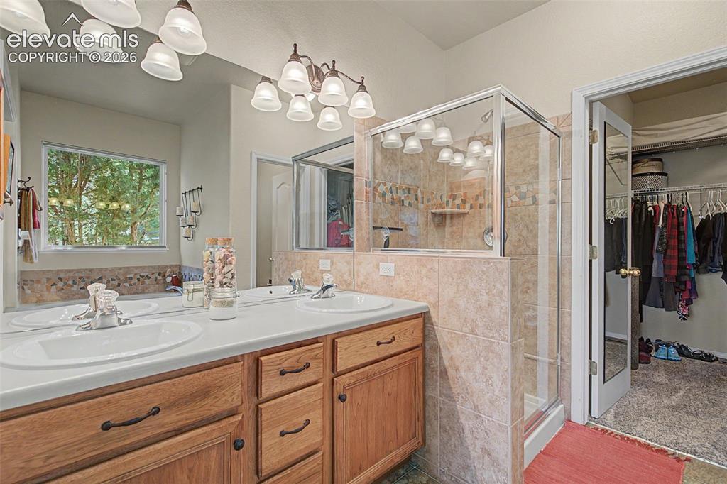 Image 12 of 31: Double vanity, full shower with a seat and walk-in closet.
