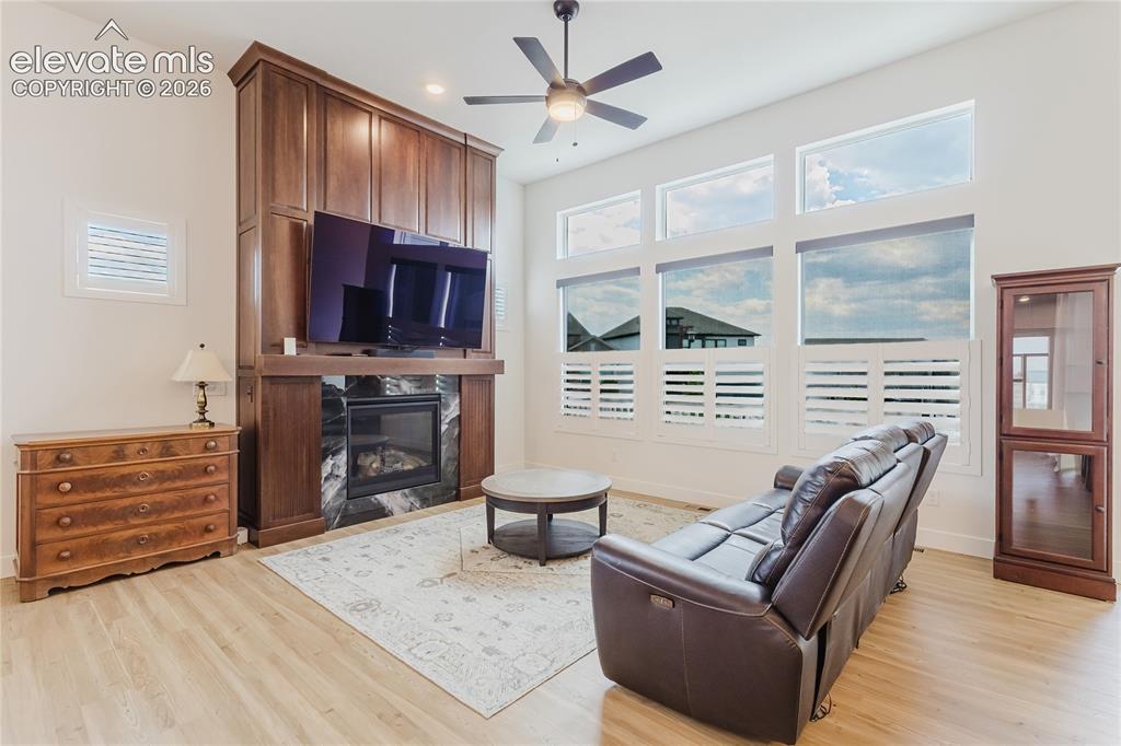 Image 22 of 46: White walls, ceiling fan, carpet flooring, multiple windows with plantation