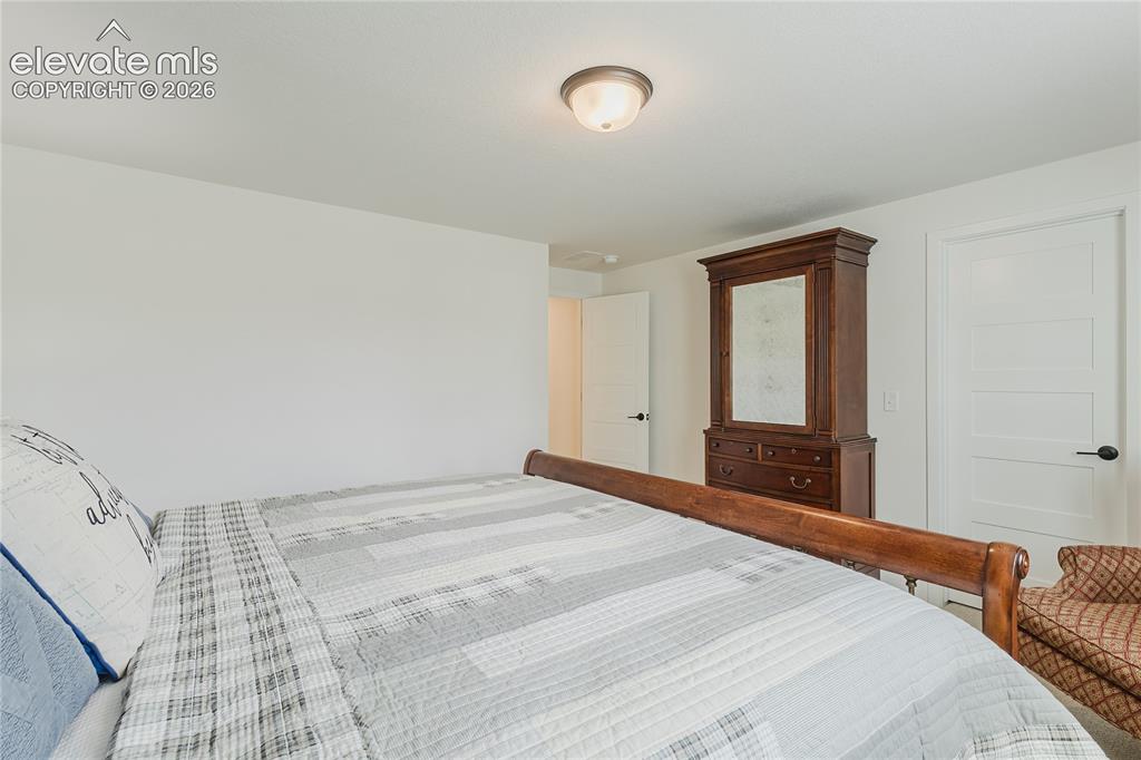 Image 37 of 46: Bedroom in the lower level with plantation shutters and a walk in closet