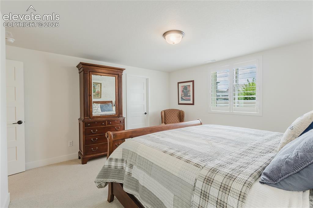 Image 38 of 46: Bedroom in the lower level with plantation shutters and a walk in closet