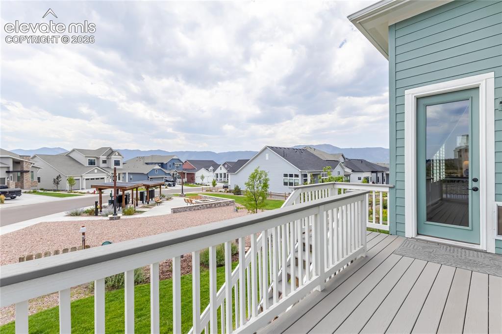 Image 45 of 46: Rear exterior featuring a spacious deck with white railings and stairs, ext