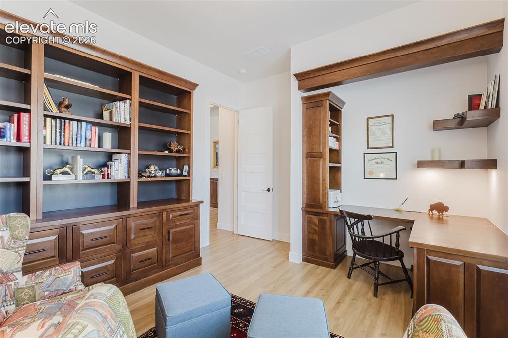 Image 6 of 46: Custom built-in bookcases with a rolling ladder, coffered ceiling with a ce