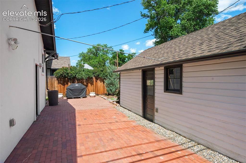 Image 39 of 48: Brick outdoor space and adjoining 1 car garage