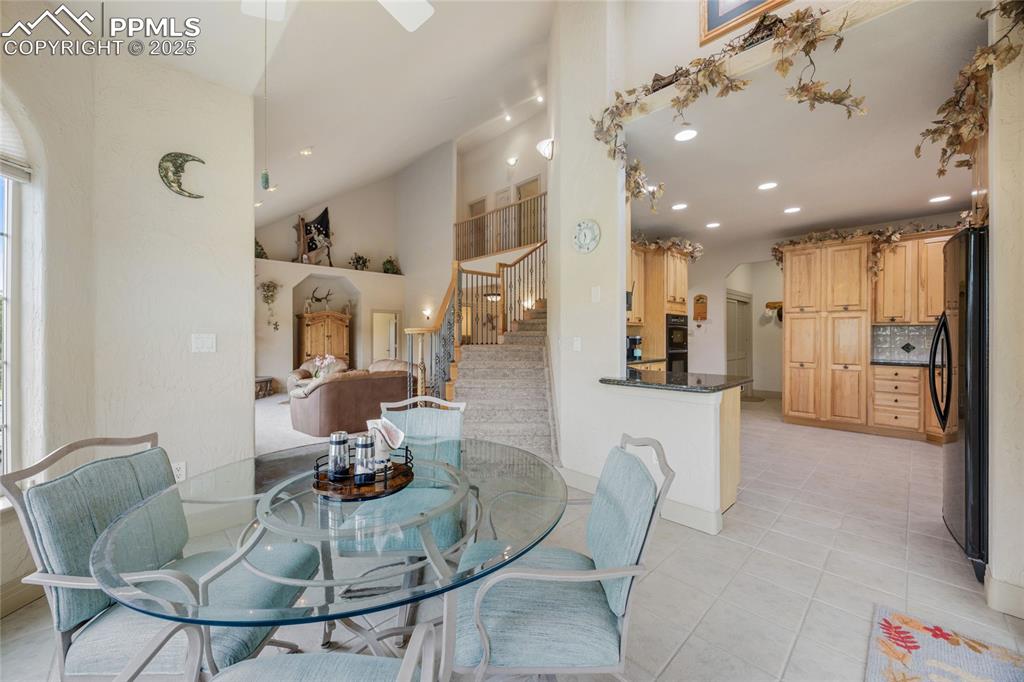 Image 15 of 41: Dining space with stairs, light tile patterned floors, recessed lighting, a