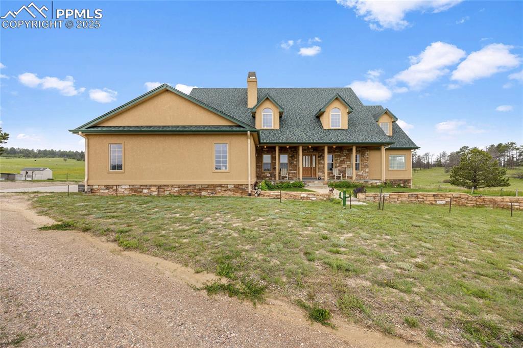 Image 2 of 41: View of front of home with a chimney, a front lawn, and stucco siding