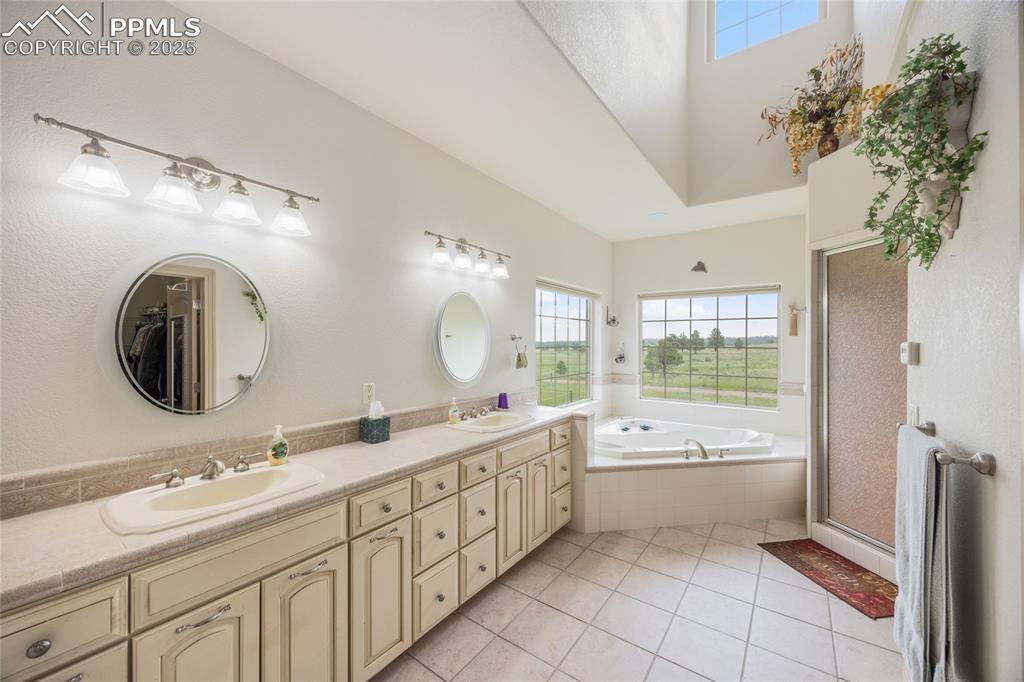 Image 30 of 41: Full bathroom featuring double vanity, a garden tub, tile patterned floorin