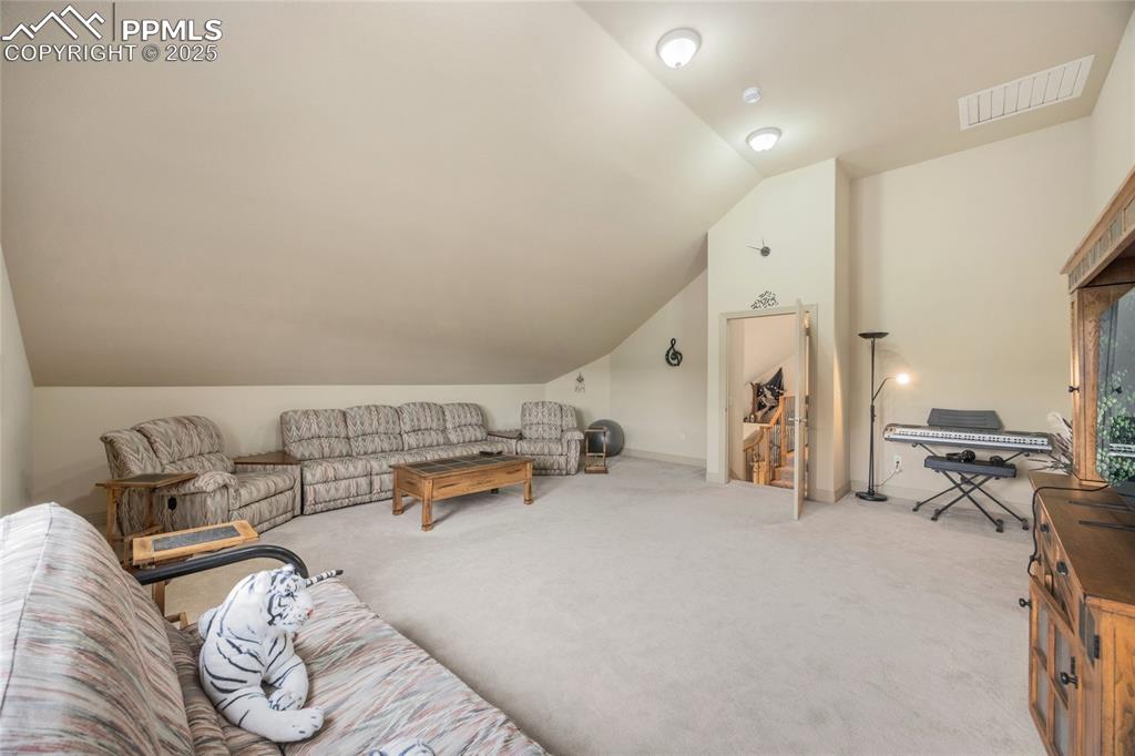 Image 35 of 41: Living room with light carpet and vaulted ceiling