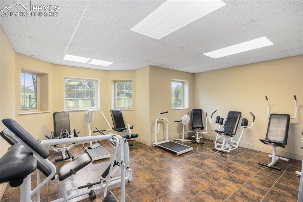 Image 40 of 41: Workout area featuring a paneled ceiling and baseboards